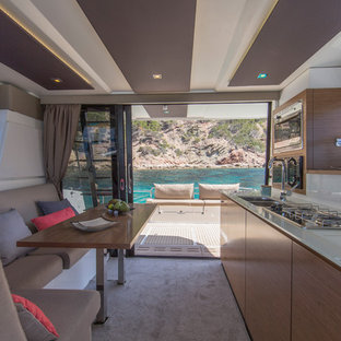 Exemple d'une cuisine américaine linéaire tendance avec un évier 2 bacs, un placard à porte plane, des portes de placard en bois brun, une crédence blanche, moquette, aucun îlot et un sol beige.