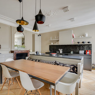 Foto di una cucina design con paraspruzzi nero, parquet chiaro, ante lisce, ante nere, top in granito e paraspruzzi con piastrelle in pietra