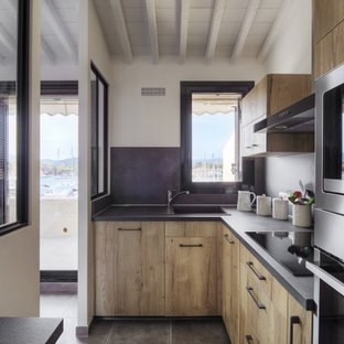 Cette photo montre une petit cuisine tendance en L fermée avec un évier 1 bac, un placard à porte affleurante, des portes de placard en bois clair, un plan de travail en marbre, une crédence noire, une crédence en marbre, un électroménager en acier inoxydable, un sol en carrelage de céramique, aucun îlot, un sol gris, un plan de travail noir et un plafond en bois.