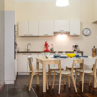 Cette image montre une cuisine ouverte design en L de taille moyenne avec des portes de placard blanches et aucun îlot.