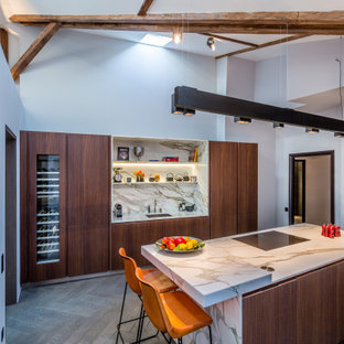 Idée de décoration pour une cuisine design avec un évier 1 bac, un placard à porte plane, des portes de placard en bois sombre, une crédence multicolore, une crédence en dalle de pierre, un électroménager encastrable, un îlot central, un sol marron, un plan de travail multicolore, un plafond en poutres apparentes et un plafond voûté.