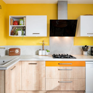 Cette image montre une cuisine design en L de taille moyenne avec un évier posé, un placard à porte plane, des portes de placard en bois clair, une crédence grise, une crédence en carreau de porcelaine, un électroménager encastrable et un plan de travail gris.