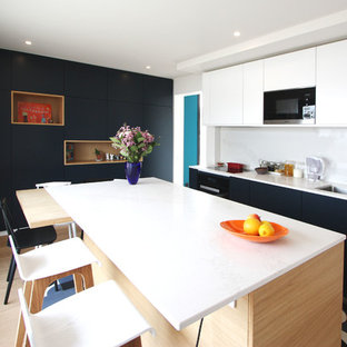 Exemple d'une grand cuisine parallèle tendance fermée avec un évier 2 bacs, un placard à porte plane, une crédence blanche, un électroménager en acier inoxydable, un îlot central, un plan de travail blanc, des portes de placard bleues, un plan de travail en quartz, une crédence en quartz modifié et un sol bleu.