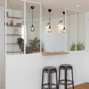 Idée de décoration pour une cuisine ouverte design en L de taille moyenne avec un plan de travail en bois, un sol en bois brun, un sol marron, un évier posé, un placard à porte plane, des portes de placard blanches, une crédence multicolore, une crédence en carreau de ciment, un électroménager en acier inoxydable, aucun îlot et un plan de travail beige.