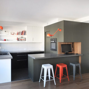 Inspiration pour une cuisine ouverte design en U de taille moyenne avec un placard à porte plane, une crédence blanche, une péninsule, un évier posé, des portes de placard noires, un plan de travail en béton, une crédence en carreau de céramique et un électroménager encastrable.