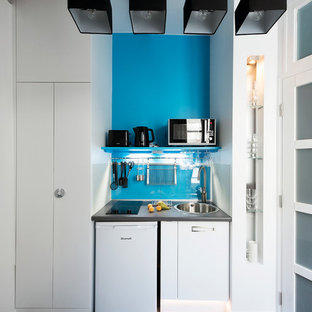 Aménagement d'une petit cuisine linéaire contemporaine fermée avec des portes de placard blanches et aucun îlot.