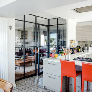 Inspiration pour une cuisine américaine design en U avec un placard à porte plane, des portes de placard beiges, une crédence beige, un sol en carrelage de céramique et une péninsule.