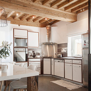 Inspiration pour une cuisine américaine en U avec un placard à porte plane, des portes de placard blanches, une crédence en dalle métallique, un électroménager en acier inoxydable, un îlot central, un sol marron et un plan de travail blanc.