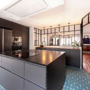Design ideas for a modern separate kitchen in Paris with an integrated sink, black cabinets, granite benchtops, black splashback, terra-cotta splashback, stainless steel appliances, blue floor and black benchtop.