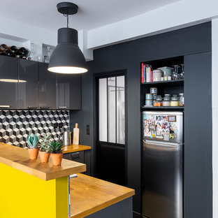 Idées déco pour une petit cuisine américaine contemporaine en U avec un évier 1 bac, un placard à porte plane, des portes de placard grises, un plan de travail en bois, une crédence en carreau de ciment, un sol en carreaux de ciment, un sol noir, une crédence multicolore, un électroménager en acier inoxydable, une péninsule et un plan de travail beige.