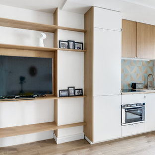 Foto de cocina lineal, escandinava, pequeña, abierta, sin isla, con encimera de madera, salpicadero azul, electrodomésticos con paneles, fregadero encastrado, puertas de armario blancas y suelo de madera clara