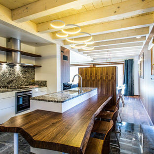 Idées déco pour une cuisine américaine linéaire contemporaine de taille moyenne avec un évier encastré, des portes de placard blanches, une crédence multicolore, un électroménager encastrable et un îlot central.