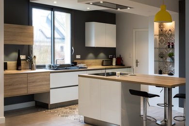 Moderne Küche mit flächenbündigen Schrankfronten und Kücheninsel in Angers