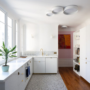 Réalisation d'une cuisine design en L de taille moyenne avec aucun îlot, des portes de placard blanches, un plan de travail en stratifié, une crédence grise, une crédence en marbre, un sol en terrazzo, un plan de travail blanc, un évier posé, un placard à porte plane et un sol multicolore.