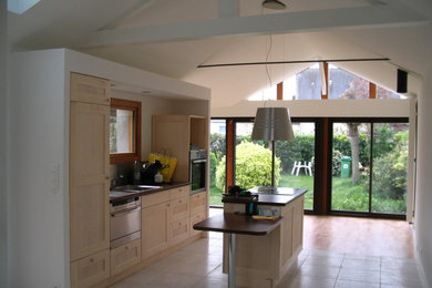 Foto di una cucina design con lavello sottopiano, ante in legno chiaro, paraspruzzi grigio, elettrodomestici in acciaio inossidabile e pavimento con piastrelle in ceramica