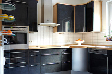 Пример оригинального дизайна: отдельная, п-образная кухня среднего размера в стиле модернизм