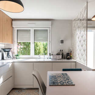 Photo of a mid-sized scandinavian u-shaped kitchen in Lyon with an integrated sink, white cabinets, quartzite benchtops, white splashback, glass sheet splashback, stainless steel appliances, cement tiles, no island, beige floor and white benchtop.