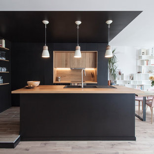 Idées déco pour une cuisine américaine contemporaine en L de taille moyenne avec un évier encastré, un plan de travail en bois, une crédence marron, une crédence en bois, un sol en bois clair et un îlot central.