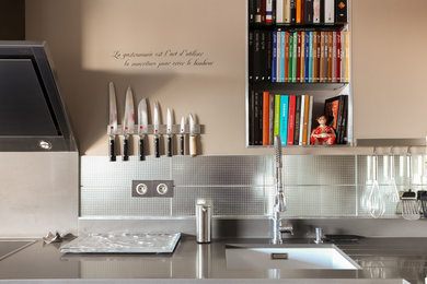 Bild på ett mellanstort funkis grå grått kök, med en enkel diskho, släta luckor, skåp i ljust trä, marmorbänkskiva, grått stänkskydd, stänkskydd i metallkakel, integrerade vitvaror, en köksö, klinkergolv i keramik och grått golv