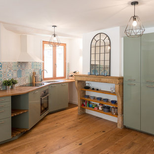 Réalisation d'une cuisine linéaire nordique fermée avec un placard à porte plane, des portes de placards vertess, un plan de travail en bois, une crédence multicolore, un électroménager en acier inoxydable, un sol en bois brun, aucun îlot et un sol marron.