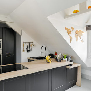 Cette image montre une cuisine ouverte nordique en U de taille moyenne avec des portes de placard grises, un plan de travail en bois, un électroménager en acier inoxydable, un sol gris, un plan de travail beige, un évier 2 bacs, un placard à porte affleurante, un sol en carreau de terre cuite et un îlot central.