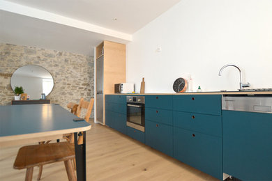 Réalisation d'une cuisine ouverte linéaire minimaliste de taille moyenne avec des portes de placard bleues.