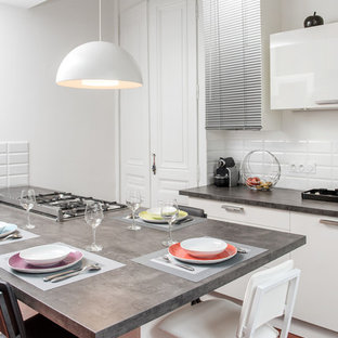 Idées déco pour une cuisine américaine parallèle contemporaine de taille moyenne avec un placard à porte plane, des portes de placard blanches, une crédence blanche, une crédence en carrelage métro et un îlot central.