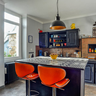 Exemple d'une grand cuisine ouverte linéaire éclectique avec un placard avec porte à panneau surélevé, des portes de placard noires, un îlot central, un sol gris, un plan de travail multicolore, un évier encastré, un plan de travail en carrelage, une crédence métallisée, une crédence en dalle de pierre, un électroménager noir et un sol en vinyl.