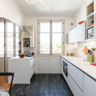 Aménagement d'une cuisine parallèle contemporaine de taille moyenne et fermée avec un évier encastré, des portes de placard blanches, un plan de travail en quartz modifié, un électroménager en acier inoxydable, un sol en carrelage de céramique, un sol noir, un placard à porte plane, une crédence blanche, une crédence en dalle de pierre, une péninsule et un plan de travail blanc.