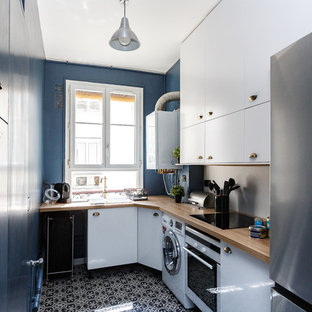 Inspiration pour une cuisine parallèle design fermée avec un évier posé, un placard à porte plane, des portes de placard bleues, un plan de travail en bois, une crédence beige, un électroménager en acier inoxydable, aucun îlot, un sol multicolore et un plan de travail beige.