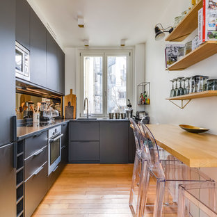 Idées déco pour une cuisine contemporaine en L fermée et de taille moyenne avec un évier encastré, des portes de placard grises, une crédence grise, un électroménager en acier inoxydable, un sol en bois clair, aucun îlot, un sol marron, un plan de travail gris et un placard à porte plane.