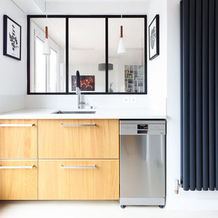 Réalisation d'une petit cuisine nordique fermée avec un évier encastré, un placard à porte plane, des portes de placard en bois clair, une crédence blanche, un électroménager en acier inoxydable, un sol blanc, un plan de travail blanc, un plan de travail en quartz et aucun îlot.