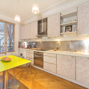 Idées déco pour une cuisine américaine linéaire contemporaine de taille moyenne avec un évier 1 bac, des portes de placard blanches, une crédence métallisée, un électroménager en acier inoxydable, un sol en bois brun et aucun îlot.