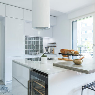 Cette image montre une cuisine américaine design avec un évier encastré, des portes de placard blanches, un plan de travail en quartz, un sol en carrelage de céramique, un îlot central et un sol beige.