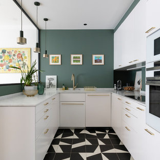 This is an example of a mid-sized contemporary u-shaped kitchen in Paris with white cabinets, green splashback, white appliances, porcelain floors, white benchtop, an undermount sink, flat-panel cabinets and multi-coloured floor.