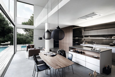 Cette image montre une cuisine ouverte parallèle design avec îlot, un placard à porte plane et une crédence grise.