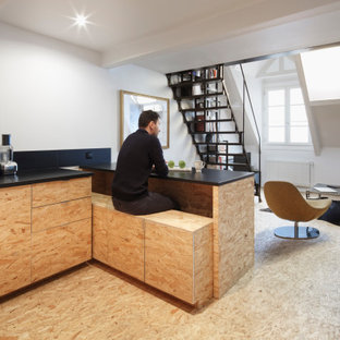 Design ideas for a mid-sized industrial u-shaped eat-in kitchen in Paris with an undermount sink, light wood cabinets, black splashback, black appliances, light hardwood floors, with island, yellow floor, black benchtop and beaded inset cabinets.
