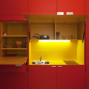 Idées déco pour une petit cuisine linéaire contemporaine fermée avec un évier 1 bac, des portes de placard rouges, une crédence jaune, aucun îlot et un plan de travail jaune.