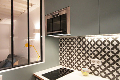 Exemple d'une petite cuisine ouverte linéaire tendance avec un évier encastré, des portes de placard bleues, un plan de travail en stratifié, une crédence en céramique, un électroménager en acier inoxydable et une crédence multicolore.