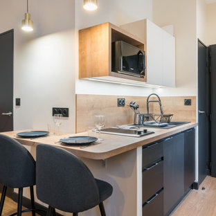 Design ideas for a small single-wall eat-in kitchen in Lyon with an undermount sink, black cabinets, laminate benchtops, beige splashback, timber splashback, black appliances, light hardwood floors, beige floor and beige benchtop.