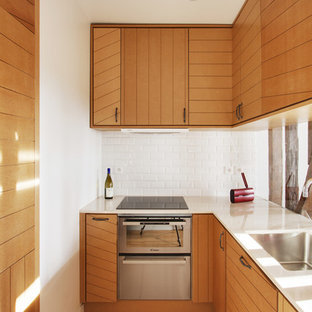 Aménagement d'une petit cuisine parallèle contemporaine fermée avec des portes de placard en bois brun.