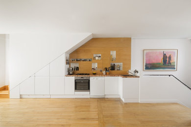 Foto de cocinas en L actual de tamaño medio con encimera de azulejos, salpicadero de madera, suelo de madera clara y encimeras multicolor