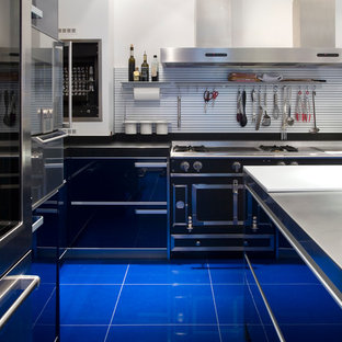 Aménagement d'une cuisine contemporaine en L fermée et de taille moyenne avec une façade en inox, un îlot central et un sol bleu.