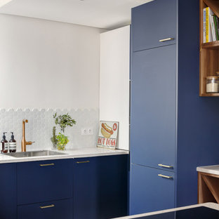 Design ideas for a mid-sized contemporary u-shaped open plan kitchen in Paris with an undermount sink, beaded inset cabinets, blue cabinets, terrazzo benchtops, white splashback, ceramic splashback, panelled appliances, ceramic floors, a peninsula, grey floor and white benchtop.