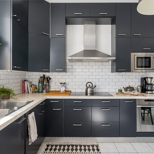 This is an example of a large scandinavian l-shaped eat-in kitchen in Lyon with a double-bowl sink, black cabinets, white splashback, stainless steel appliances, ceramic floors and no island.