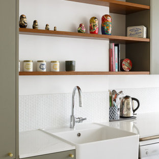Offene, Einzeilige, Mittelgroße Moderne Küche mit Unterbauwaschbecken, flächenbündigen Schrankfronten, grünen Schränken, Küchenrückwand in Weiß, Rückwand aus Zementfliesen, Küchengeräten aus Edelstahl, Terrazzo-Boden, Kücheninsel, buntem Boden und weißer Arbeitsplatte in Paris