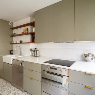 Foto de cocina lineal, moderna, de tamaño medio, abierta, con fregadero bajoencimera, armarios con paneles lisos, puertas de armario verdes, salpicadero blanco, salpicadero de azulejos de cemento, electrodomésticos de acero inoxidable, suelo de terrazo, una isla, suelo multicolor y encimeras blancas