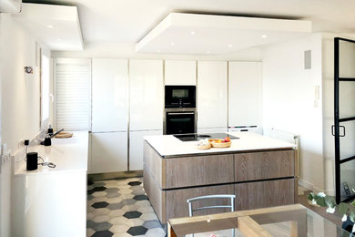 パリにあるラグジュアリーな巨大なコンテンポラリースタイルのおしゃれなキッチン (アンダーカウンターシンク、インセット扉のキャビネット、白いキャビネット、珪岩カウンター、白いキッチンパネル、黒い調理設備、セメントタイルの床、マルチカラーの床、白いキッチンカウンター) の写真