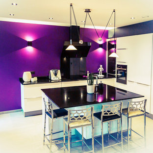 Mid-sized modern l-shaped separate kitchen in Other with an integrated sink, granite benchtops, panelled appliances, with island, white floor and black benchtop.