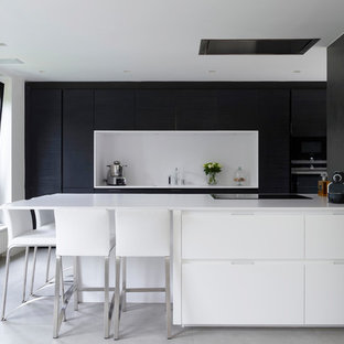 Idées déco pour une cuisine moderne avec un plan de travail en quartz modifié, une crédence blanche, un sol en carrelage de céramique, un placard à porte plane, des portes de placard blanches, une péninsule et un sol gris.